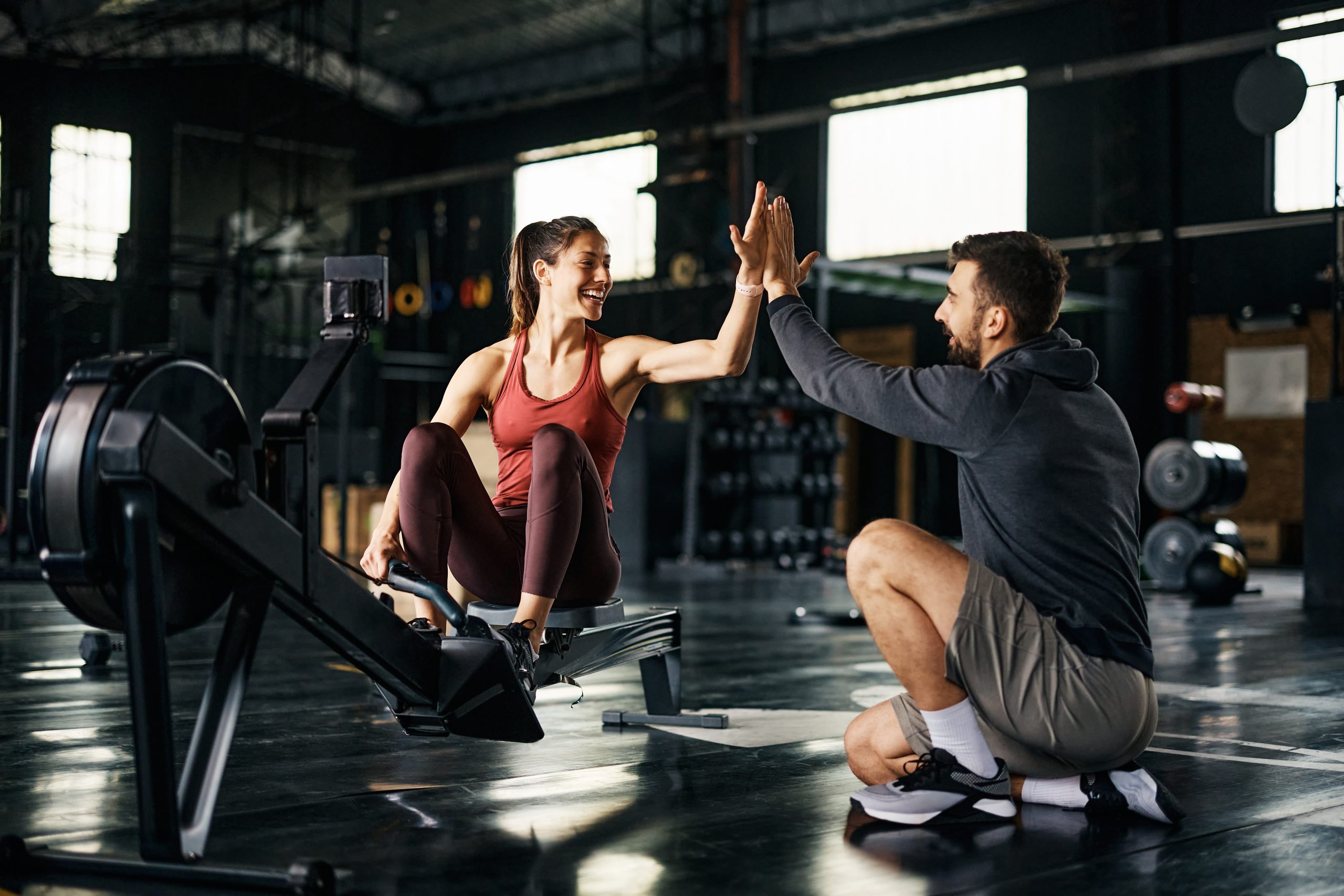 women on exercising machine working with a personal trainer on an exercise